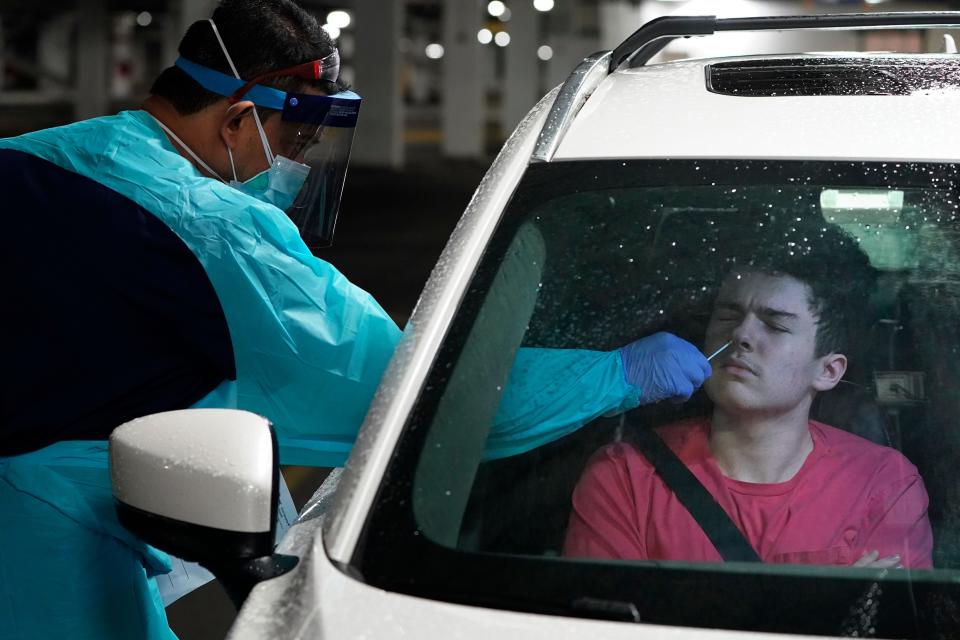 A  high school student is tested for COVID-19 at a drive-through testing site in a parking garage in West Nyack on Nov. 30, 2020.