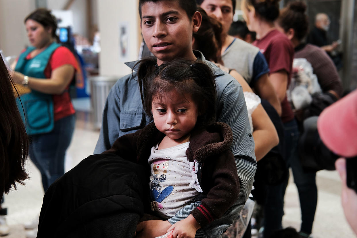Women, men and children, many fleeing poverty and violence in Honduras, Guatemala and El Salvador, arrive at a bus station following release from Customs and Border Protection on June 23 in McAllen, Texas. (Photo: Spencer Platt via Getty Images)
