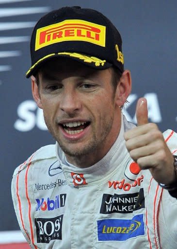 McLaren-Mercedes driver Jenson Button of Britain celebrates his victory during the award ceremony for the Formula One Japanese Grand Prix at Suzuka on October 9. Germany's Sebastian Vettel became F1's youngest back-to-back world champion when he finished third in the Japanese GP behind Button and Fernando Alonso