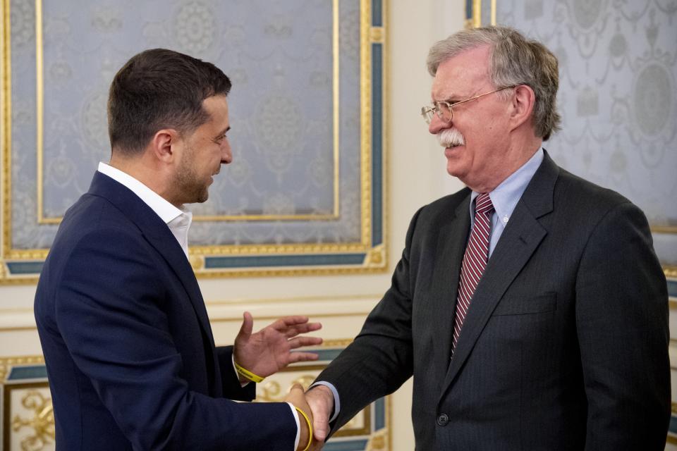 FILE - In this file photo taken on Aug. 28, 2019, John Bolton, U.S. National Security Advisor, right, is welcomed Ukrainian President Volodymyr Zelenskiy in Kyiv, Ukraine. Ukrainian President Volodymyr Zelenskiy's first 100 days in power were marked by his efforts to advance a peaceful solution to the armed conflict in the country's east, fomented by Russia. Now, he is caught up in a political furor involving the United States, Ukraine's ally and backer. (Ukrainian Presidential Press Office via AP, File)