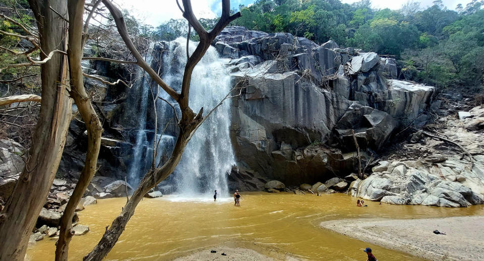 People standing at the bottom of Trevathan Falls where the swimming hole was.