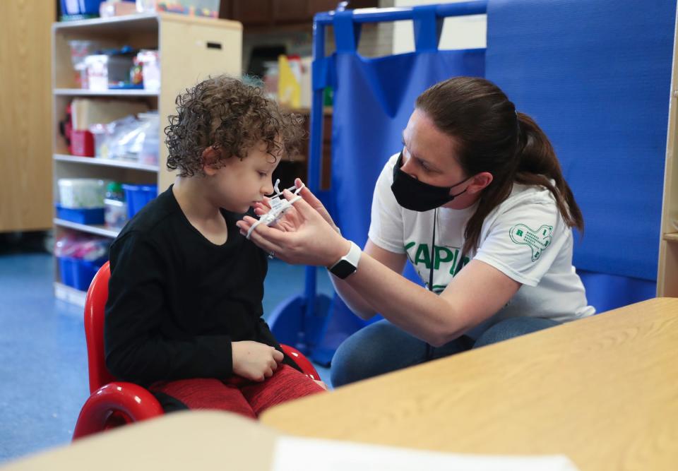 Teacher Katie Galvin helps a student with a mask at the Jesse Kaplan School in West Nyack in April 2021.