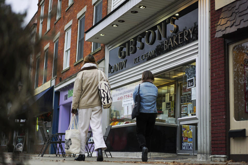 FILE - In this Nov. 22, 2017 file photo, pedestrians pass the storefront of Gibson's Food Mart & Bakery in Oberlin, Ohio. A jury has awarded $11 million to a father and son who claimed Ohio's Oberlin College and an administrator hurt their business and libeled them during a dispute that triggered protests and allegations of racism following a shoplifting incident. (AP Photo/Dake Kang, File)