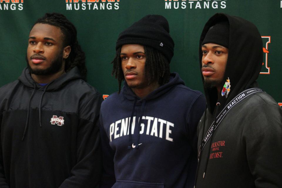 Mandarin cornerback Jon Mitchell, a Penn State signee, is flanked by brothers Nic Mitchell (Mississippi State linebacker) and Kris Mitchell (Notre Dame wide receiver) during early signing day ceremonies.