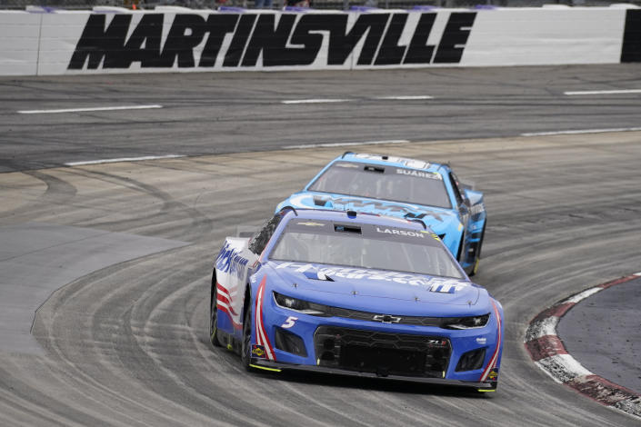 Kyle Larson (5) leads Daniel Suarez (99) out of Turn 4 during a NASCAR Cup Series auto race at Martinsville Speedway, Sunday, Oct. 30, 2022, in Martinsville, Va. (AP Photo/Chuck Burton)
