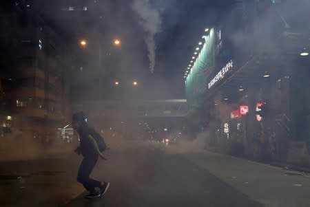 An anti-extradition bill protester runs after the police fired tear gas to disperse the demonstration at Sham Shui Po, in Hong Kong