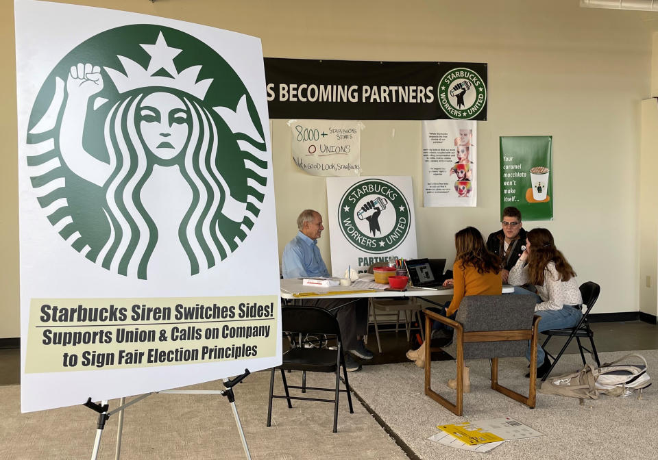 Richard Bensinger, left, who is advising unionization efforts, along with baristas Casey Moore, right, Brian Murray, second from left, and Jaz Brisack, second from right, discuss their efforts to unionize three Buffalo-area stores, inside the movements headquarters on Thursday, Oct. 28, 2021 in Buffalo, N.Y. Workers at three Starbucks stores in Buffalo will hold union elections next month after winning a case before the National Labor Relations Board. (AP Photo/Carolyn Thompson).