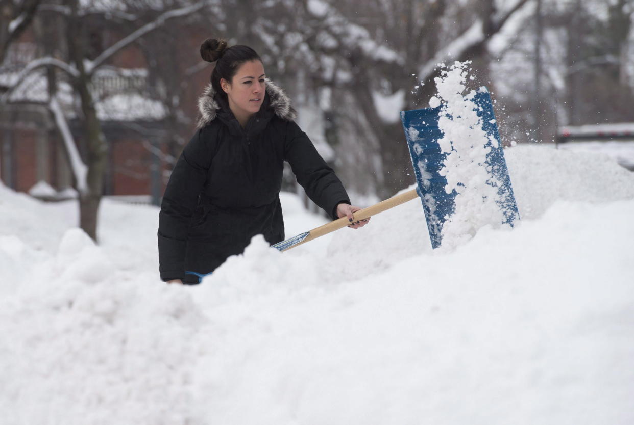 Alexandra Aversa clears snow from her driveway in the Ottawa area. THE CANADIAN PRESS/Adrian Wyld