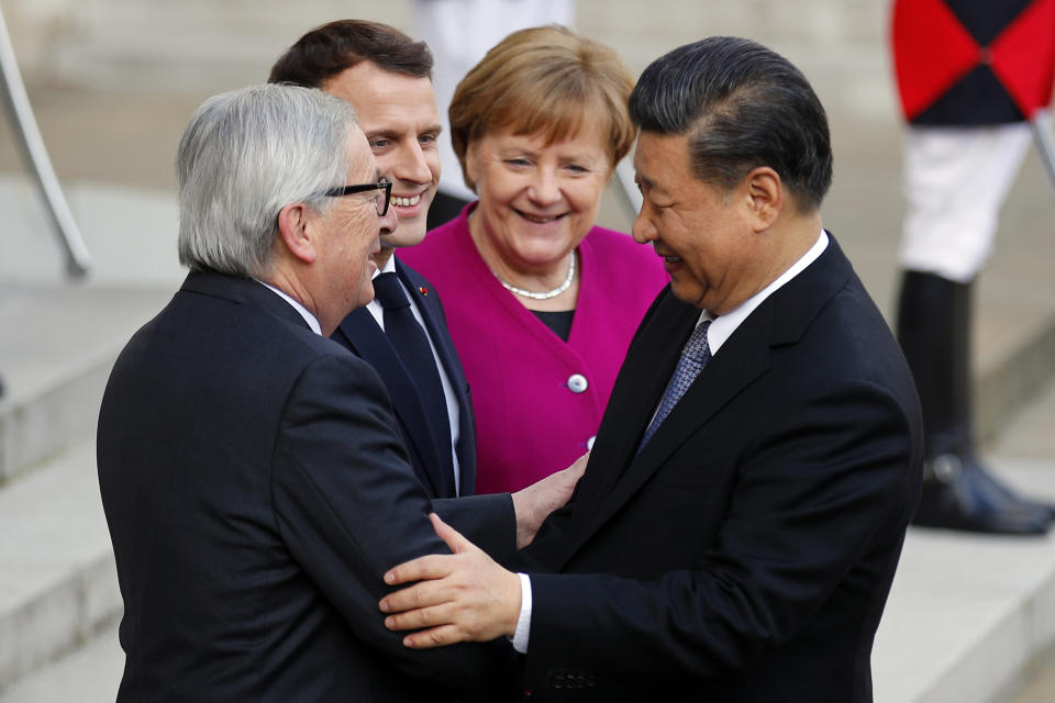 Chinese President Xi Jinping, is welcomed by French President Emmanuel Macron, 2nd right, with German Chancellor Angela Merkel, right, and European Commission President Jean-Claude Juncker, left, prior to their meeting at the Elysee presidential palace in Paris, Tuesday, March 26, 2019. Merkel and Juncker are meeting with Macron as they prepare for a possibly chaotic Brexit and a crucial summit with China. (AP Photo/Francois Mori)