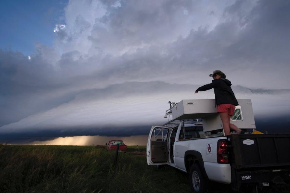 A woman stands in the back of truck working on a LiDAR system