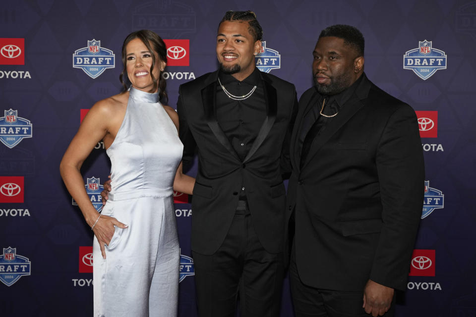 Washington wide receiver Rome Odunze, center, poses on the red carpet ahead of the first round of the NFL football draft, Thursday, April 25, 2024, in Detroit. (AP Photo/Carlos Osorio)