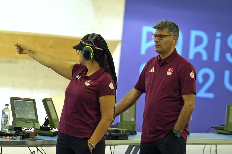 Los tiradores turcos Sevval Ilayda Tarhan (izquierda) y Yusuf Dikec se aprestan a competir en la ronda clasificatoria de los equipos mixtos con pistola de aire a 10 metros en los Juegos Olímpicos de París, el lunes 19 de julio de 2024, en Chateauroux, Francia (AP Foto/Manish Swarup)