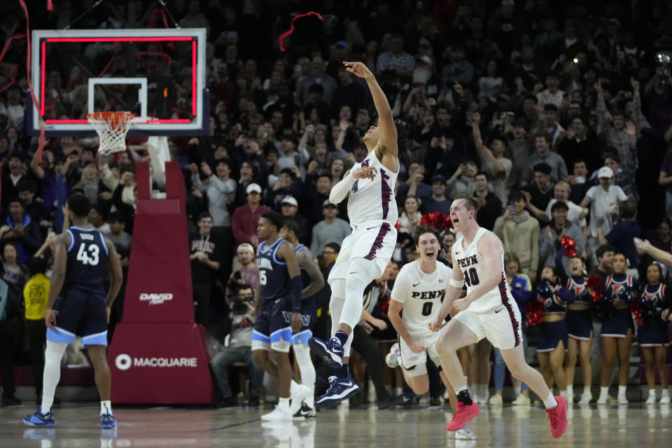 Pennsylvania's Tyler Perkins (4), Clark Slajchert (0) and George Smith (40) celebrate after Pennsylvania won an NCAA college basketball game against Villanova, Monday, Nov. 13, 2023, in Philadelphia. (AP Photo/Matt Slocum)