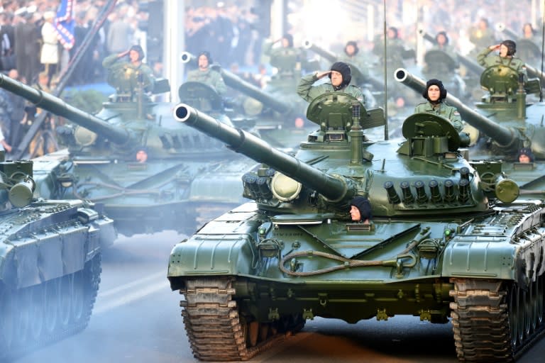 Croatian soldiers salute on top of armored vehicles on August 4, 2015 in Zagreb, during a military parade to mark the 20th anniversary of Operation Storm