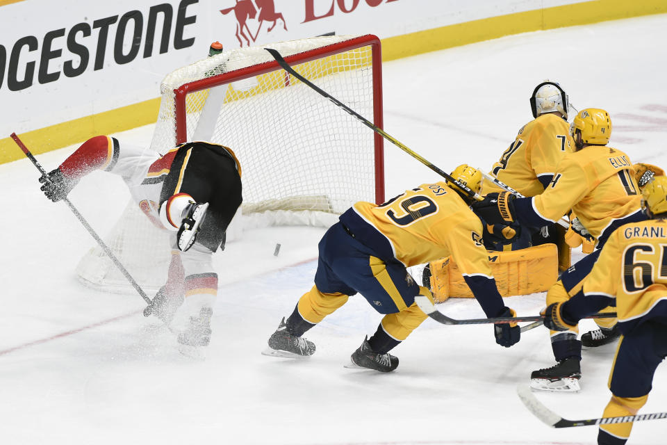 Calgary Flames center Mikael Backlund, left, of Sweden, moves toward the net after a go-ahead goal in the third period by teammate left wing Andrew Mangiapane (88) in an NHL hockey game against the Nashville Predators, Thursday, Feb. 27, 2020, in Nashville, Tenn. (AP Photo/Mark Zaleski)