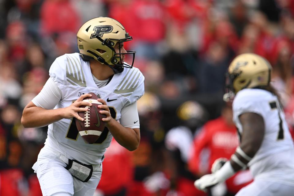 Oct 8, 2022; College Park, Maryland, USA;  Purdue Boilermakers quarterback Aidan O'Connell (16) rolls out to pass during the first half against the Purdue Boilermakers at SECU Stadium.