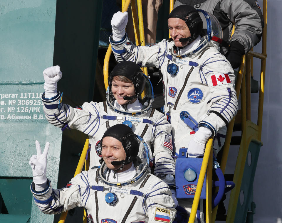 U.S. astronaut Anne McClain, centre, Russian cosmonaut Оleg Kononenko and CSA astronaut David Saint Jacques, top, crew members of the mission to the International Space Station, ISS, wave as they board to the rocket prior to the launch of Soyuz-FG rocket at the Russian leased Baikonur cosmodrome, Kazakhstan, Monday, Dec. 3, 2018. (AP Photo/Shamil Zhumatov, Pool)