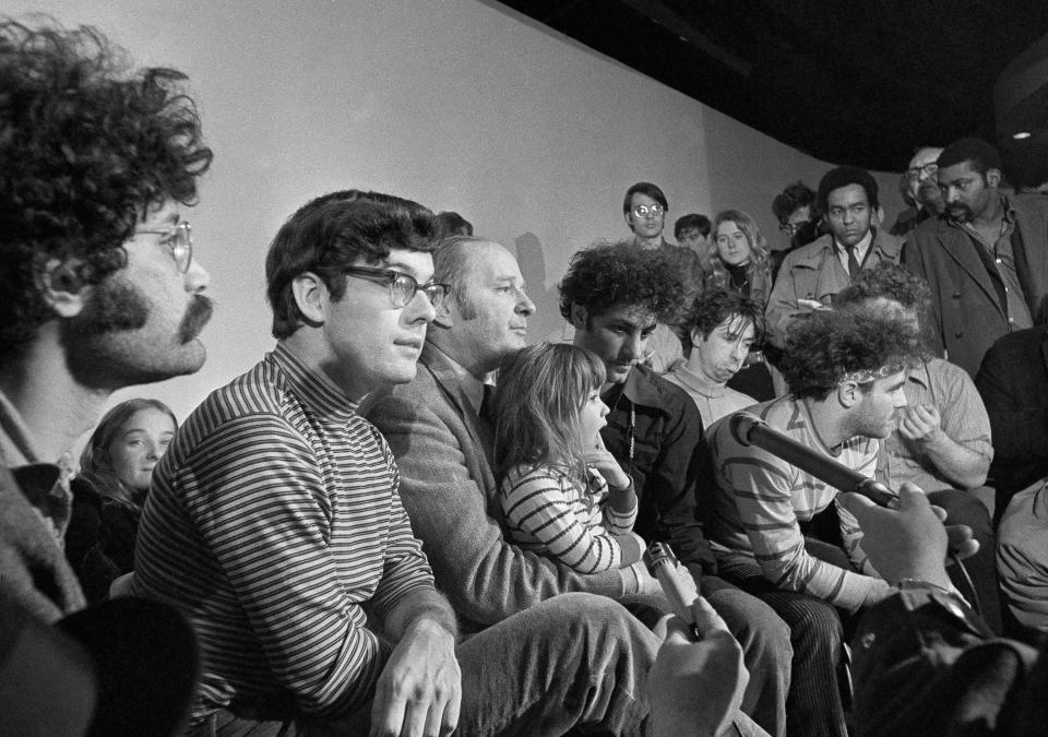 FILE - In this Feb. 28, 1970, file photo, the seven defendants in the Chicago Conspiracy Trial hold a press conference in Chicago after the 7th Circuit U.S. Court of Appeals granted their request for bail. Left to right, Lee Weiner, Rennie Davis, David Dellinger, Abbie Hoffman, Tom Hayden, (behind Hoffman), Jerry Rubin and John Froiners. Dellinger holds his granddaughter, Michelle Burd. Davis, one of the "Chicago Seven" who was tried for organizing an anti-Vietnam War protest outside the 1968 Democratic National Convention in Chicago that turned violent, has died at age 80. Davis died on Tuesday, Feb. 2, 2021, of lymphoma at his home in Berthoud, Colo. (AP Photo/JLP, File)