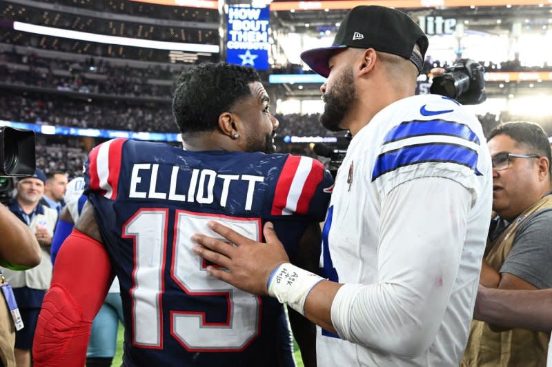 New England Patriots running back Ezekiel Elliott (L) speaks to Dallas Cowboys quarterback Dal Prescott on Sunday at AT&ampT Stadium in Arlington, Texas. Photo by Ian Halperin/UPI