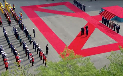 The two leaders take part in the red carpet ceremony at the DMZ - Credit: Reuters