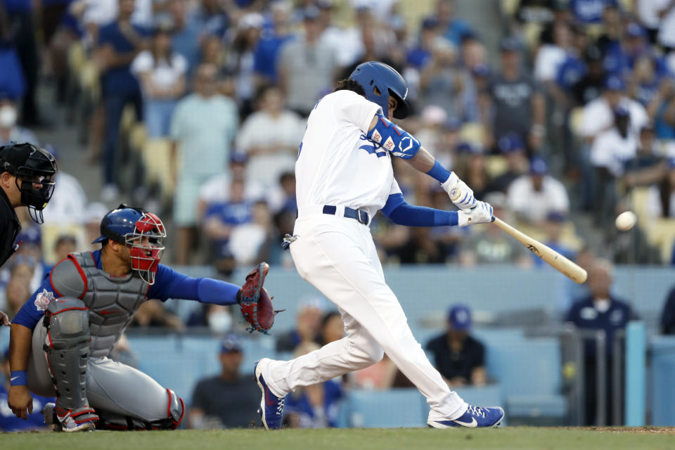 Los Angeles Dodgers' Cody Bellinger, right, hits the game winning solo home run with Chicago Cubs catcher Willson Contreras, center, and home plate umpire Jeremy Riggs watching during the ninth inning of a baseball game in Los Angeles, Saturday, June 26, 2021. The Dodgers won 3-2. (AP Photo/Alex Gallardo)