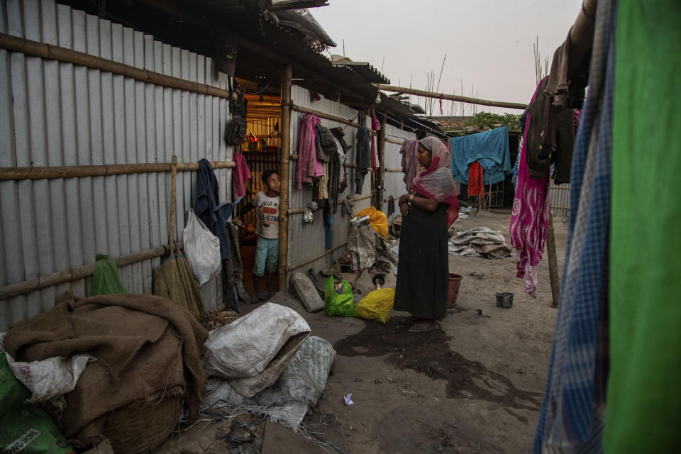 Imradul Ali, 10, left, talks to his mother Anuwara Beghum, 30, at his rented house after returning from a landfill on the outskirts of Gauhati, India, Thursday, Feb. 4, 2021. Once school is done for the day, Ali, rushes home to change out of his uniform so that he can start his job as a scavenger in India’s remote northeast. Coming from a family of scavengers or “rag pickers," Ali started doing it over a year ago to help his family make more money. Ali says he doesn’t want to spend his life doing this, but he doesn’t know what the future holds. (AP Photo/Anupam Nath)