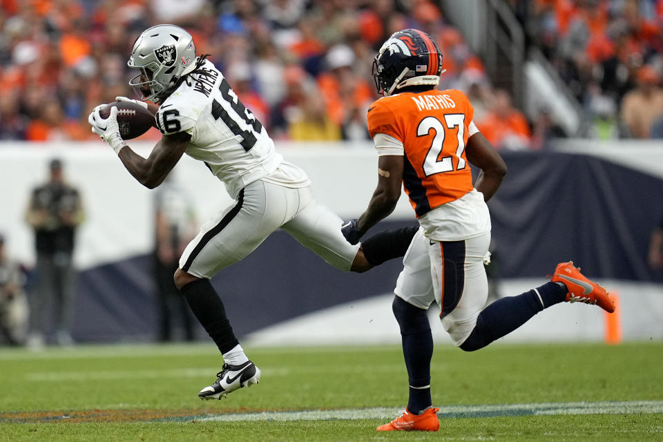 Las Vegas Raiders wide receiver Jakobi Meyers, left, makes a catch as Denver Broncos cornerback Damarri Mathis (27) defends during the second half of an NFL football game, Sunday, Sept. 10, 2023, in Denver. (AP Photo/Jack Dempsey)