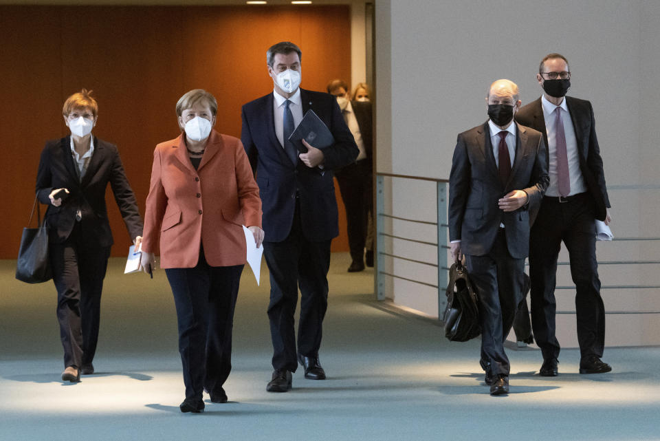 Chancellor Angela Merkel, 2nd left, together with Michael Mueller, right,, Governing Mayor of Berlin, Olaf Scholz, 2nd right, Federal Minister of Finance, and Markus Soeder, Prime Minister of Bavaria, go to a press conference at the Federal Chancellery after the switching conference of Chancellor Merkel and the Federal Government with the Prime Ministers of the federal states to announce the further course of action in the corona crisis. In view of the spreading corona pandemic, public life in Germany is to be drastically reduced as early as next Wednesday. (Bernd von Jutrczenka/Pool via AP)