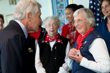 Phyllis Gould (R) shows Secretary of Defense Chuck Hagel a badge that she wore while working during World War II, during a visit at the Pentagon, in Arlington, Virginia, U.S., March 31, 2014. Erin A. Kirk-Cuomo/DOD/Handout via REUTERS