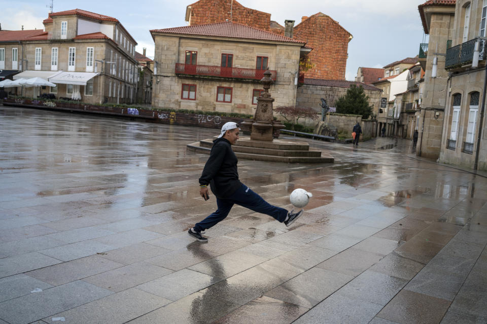 A young resident playing ball in an open plaza.