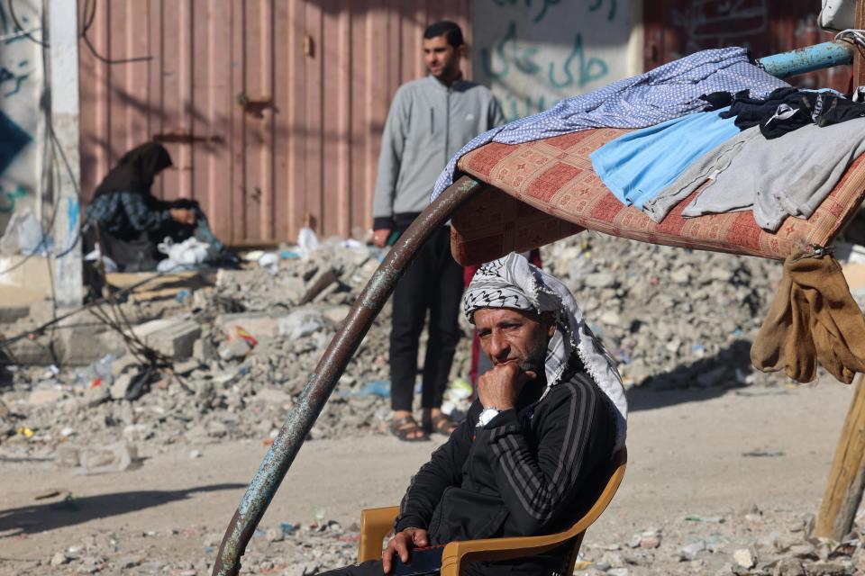 A displaced Palestinian man sits amid the rubble of buildings destroyed in an Israeli strike in Rafah in the southern Gaza Strip on Feb. 11, 2024.