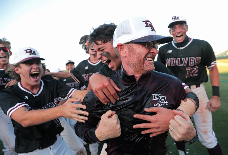 Desert Mountain head coach Ryan Dyer. Is mobbed by his players after winning the 5A baseball state championship game against Sunrise Mountain 6-1 in Tempe, Ariz. on May 17, 2021.