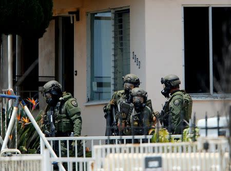 A police SWAT team leaves a home they had surrounded while searching for a second suspect after a San Diego police officer was fatally shot and another was wounded late on Thursday, in San Diego, California, United States July 29, 2016. REUTERS/Mike Blake