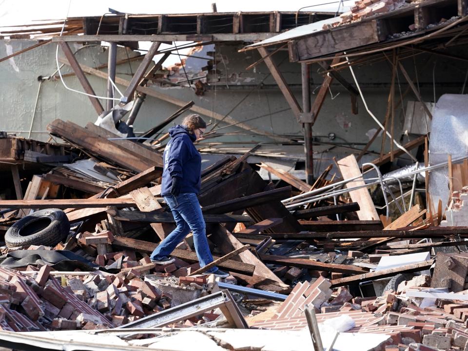 People survey damage from a tornado is seen in Mayfield, Ky., on Saturday, Dec. 11, 2021 (AP)
