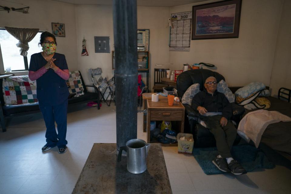 A woman and her uncle in a home with a stove for heating.