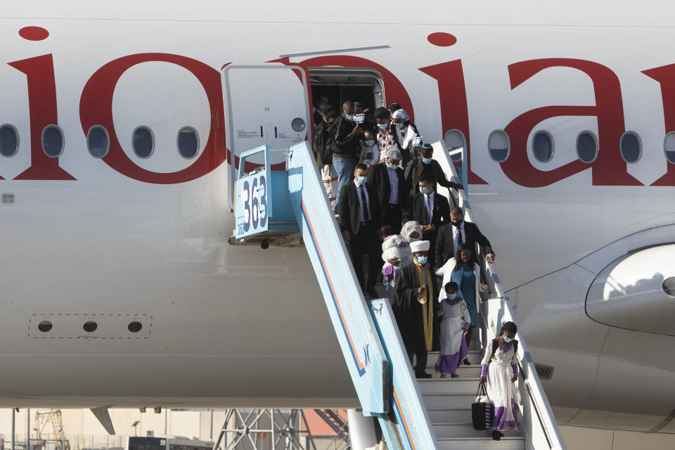 Ethiopian immigrants arrive at the Ben Gurion airport near Tel Aviv, Israel, Thursday, Dec. 3, 2020. Hundreds of Ethiopian immigrants on Thursday arrived to a festive ceremony at Israel's international airport, as the government took a step toward carrying out its pledge to reunite hundreds of families split between the two countries. (AP Photo/Sebastian Scheiner)