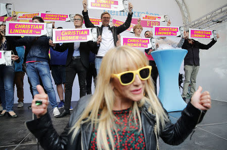 Supporters of Germany's Free Democrats Party (FDP) hold posters of the party leader Christian Lindner during the final campaign rally in Duesseldorf, Germany, September 23, 2017. REUTERS/Wolfgang Rattay