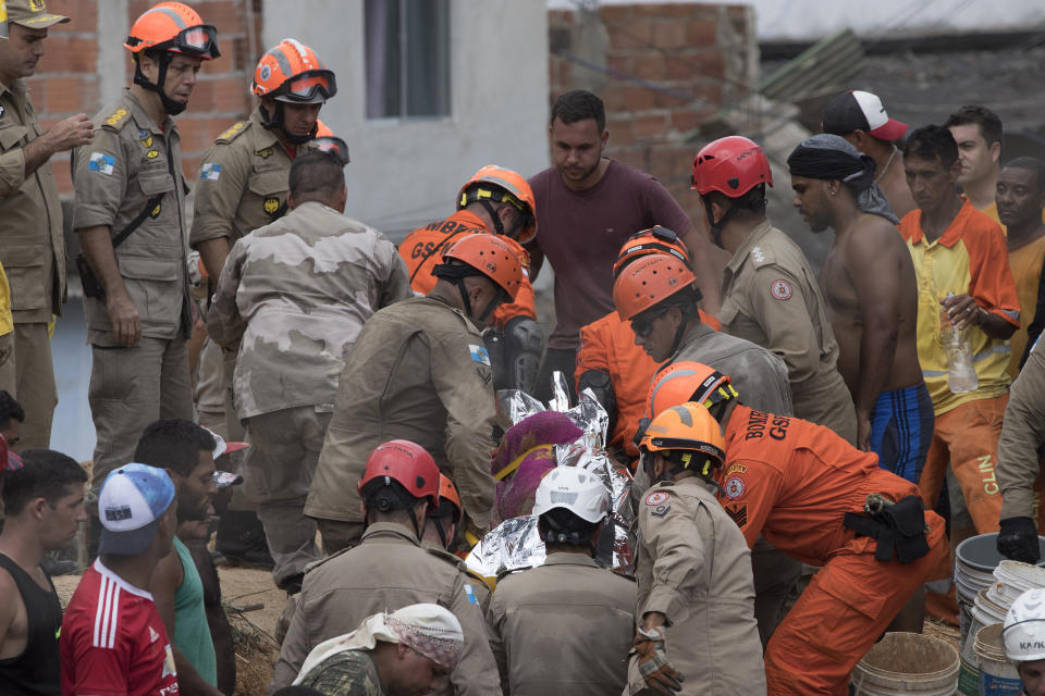 Firefighters carry a body that was found under the debris after a mudslide in Boa Esperanca or "Good Hope" shantytown in Niteroi, Brazil, Saturday, Nov. 10, 2018. Several people were killed and others injured in a mudslide near Rio de Janeiro on Saturday, Brazilian authorities said. (AP Photo/Leo Correa)