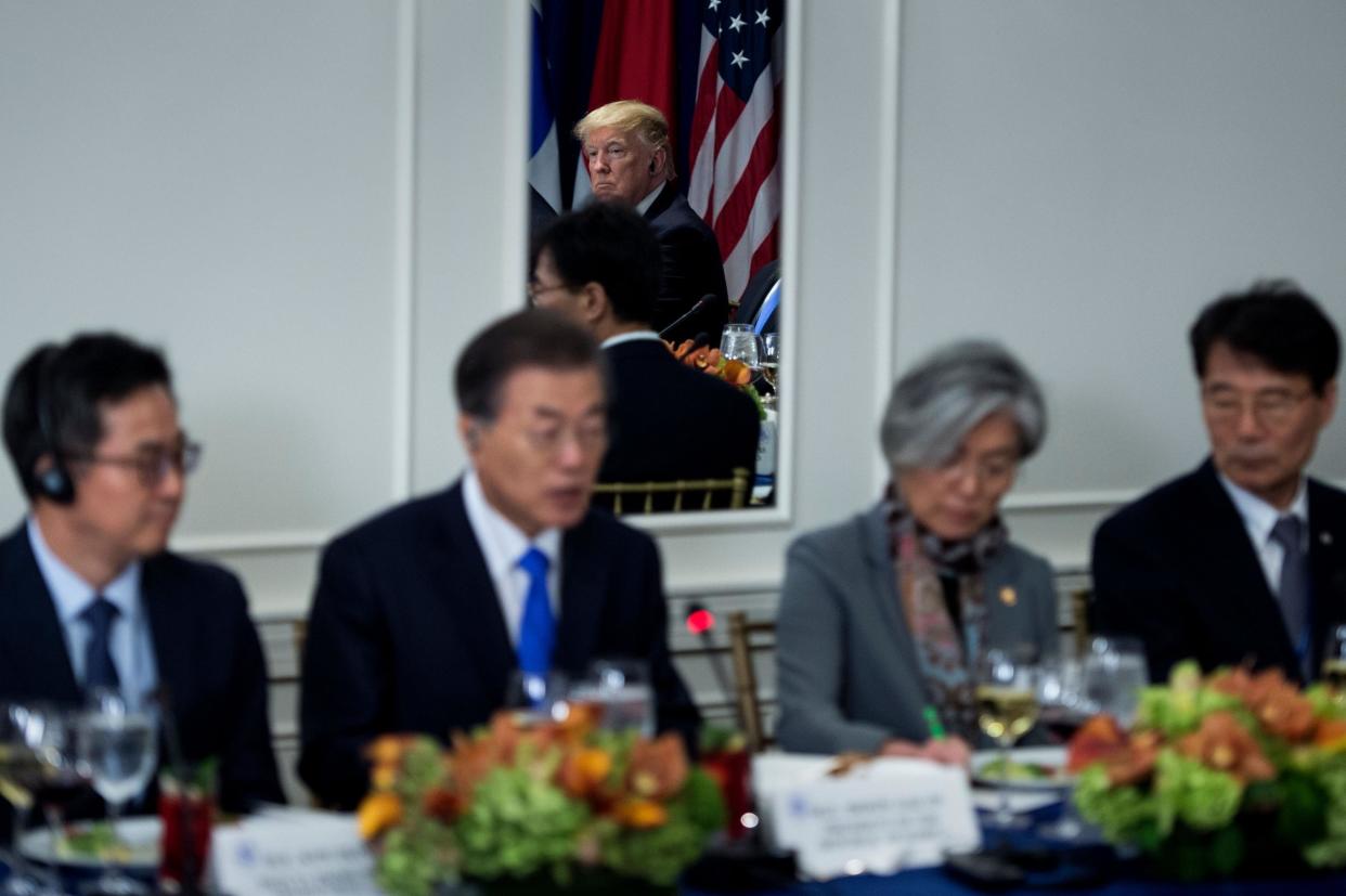 Mr Trump is seen in a mirror listening while South Korea's President Moon Jae-in speaks before luncheon between US, Korean and Japanese leaders in New York: AFP/Getty Images