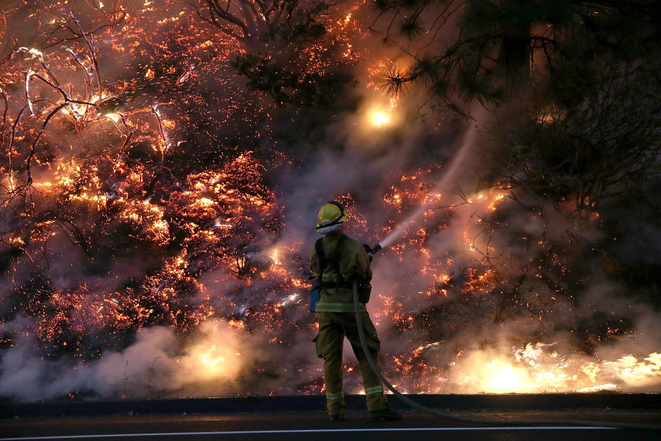  A firefighter uses a hose to douse the flames of the Rim Fire on August 24, 2013 near Groveland, California. The Rim Fire continues to burn out of control and threatens 4,500 homes outside of Yosemite National Park. Over 2,000 firefighters are battling the blaze that has entered a section of Yosemite National Park and is currently 5 percent contained. 