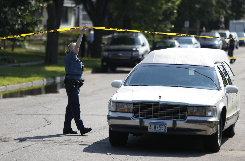 St. Paul Police officer Colleen Lesedil lifs crime scene tape, as the Ramsey county medical examiner leaves the scene with the body of a person that was shot and killed by St. Paul police in the 900 block of St. Anthony Avenue Sunday, Aug. 5, 2018, in St. Paul, Minn. Police say officers shot an armed man while responding to a 911 call early Sunday about shots fired at a home. (Jerry Holt/Star Tribune via AP)