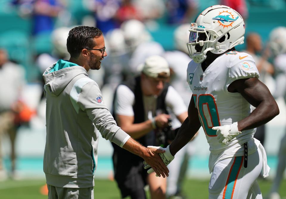 Miami Dolphins head coach Mike McDaniel greets Tyreek hill during warm-ups before the game against the Buffalo Bills at Hard Rock Stadium in Miami Gardens, Sept. 25, 2022. They've helped the Dolphins develop one of the NFL's most dynamic offenses.