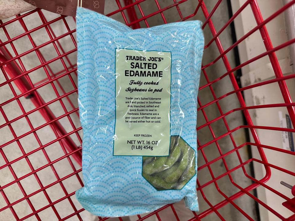 bag of frozen edamame from trader joe's in a red shopping cart