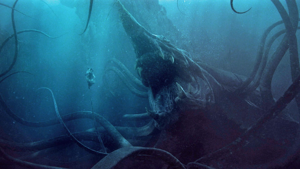 A woman floats in some water as a giant tentacle monster approaches in The Rings if Power season 2