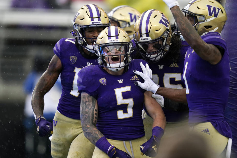Washington running back Sean McGrew (5) celebrates his touchdown run against Arkansas State with teammates in the first half of an NCAA college football game, Saturday, Sept. 18, 2021, in Seattle. (AP Photo/Elaine Thompson)