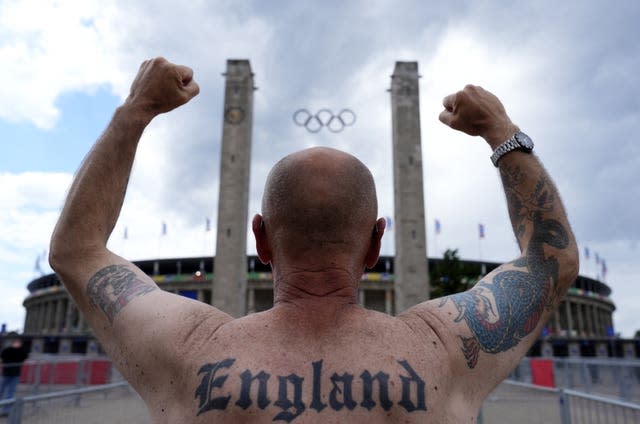 A tattooed England fan faces the Olympiastadion with his arms raised– UEFA Euro 2024 – Final – Build Up