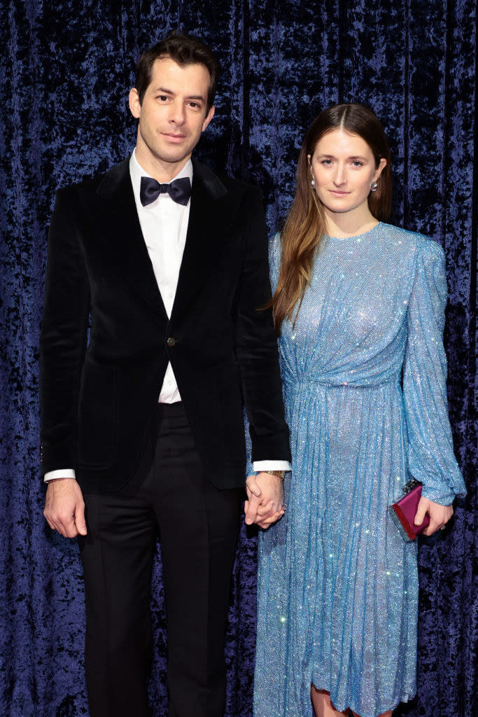 the couple holding hands on the red carpet