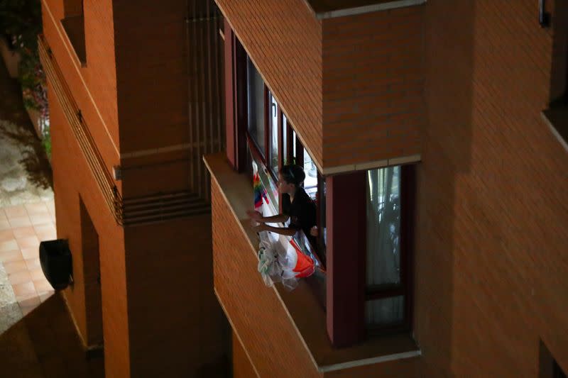 People applaud from their apartment windows as part of an event organized through social media to show gratitude to healthcare workers during the coronavirus outbreak, in Madrid