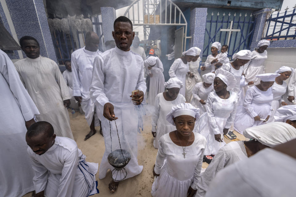 An usher wafts incense as members of the congregation sing and chant during a church service in which they prayed for the country ahead of elections and against the forces of evil, at the Celestial Church of Christ Olowu Cathedral on Lagos Island in Nigeria Friday, Feb. 24, 2023. Nigerian voters are heading to the polls Saturday to select a new president following the second and final term of incumbent President Muhammadu Buhari. (AP Photo/Ben Curtis)