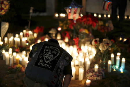 Aidan Solis, 11, kneels by a pop-up memorial in San Bernardino, California December 4, 2015, following Wednesday's attacks. REUTERS/Mario Anzuoni